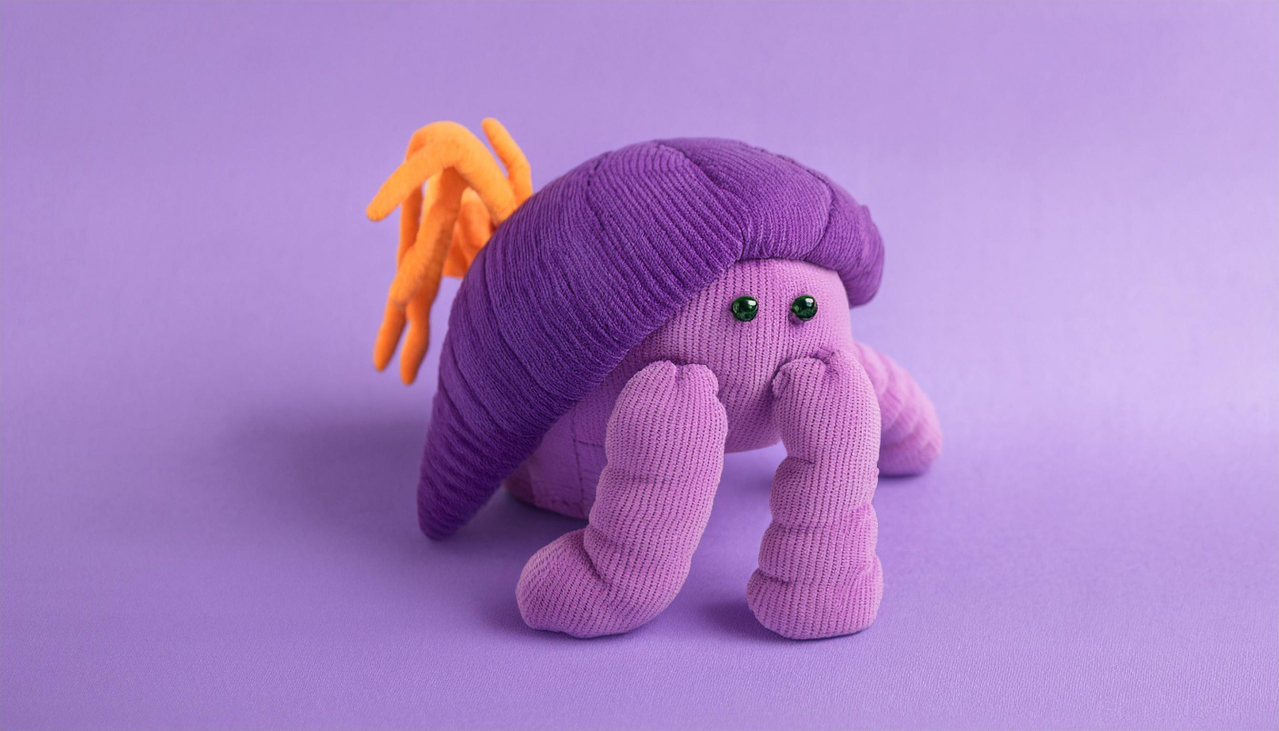 Firefly bright coloured soft plush toy of a hermit crab on a light purple thro 91183